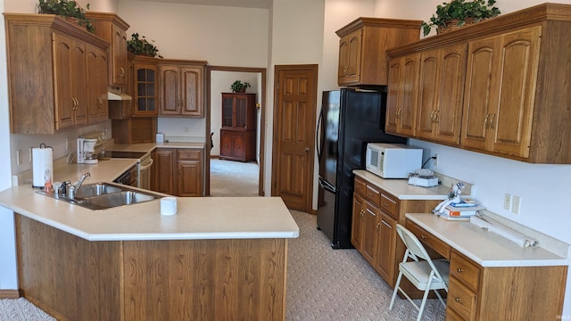 kitchen featuring sink, built in desk, white appliances, and kitchen peninsula