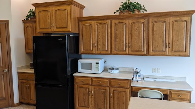 kitchen with black refrigerator and built in desk