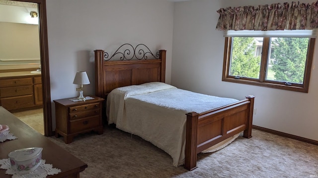 carpeted bedroom featuring ensuite bath