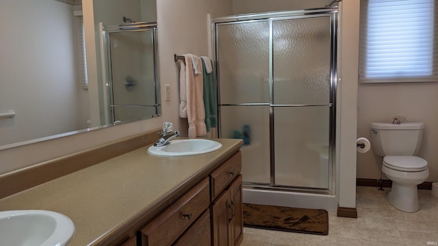 bathroom featuring vanity, toilet, and a shower with shower door