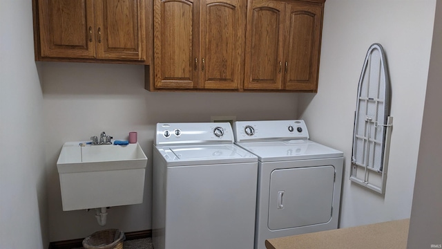 laundry area featuring cabinets, independent washer and dryer, and sink