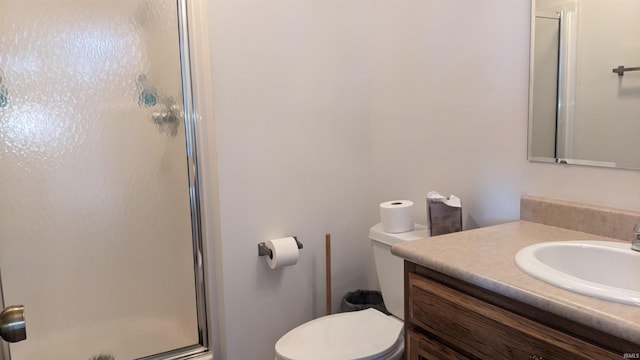 bathroom with vanity, a shower with shower door, and toilet