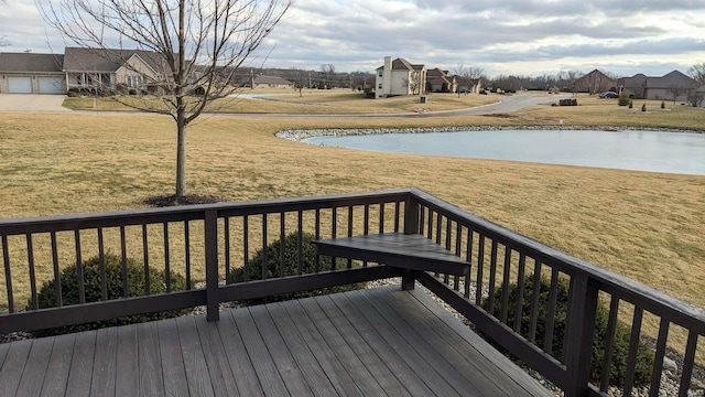 wooden terrace with a water view and a yard