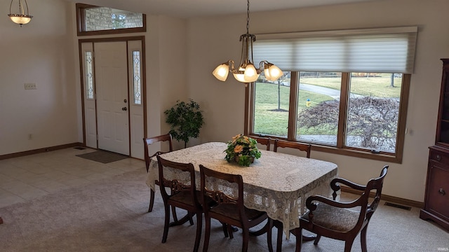 dining area featuring light carpet and a notable chandelier