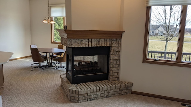 interior space featuring a brick fireplace, a healthy amount of sunlight, and carpet