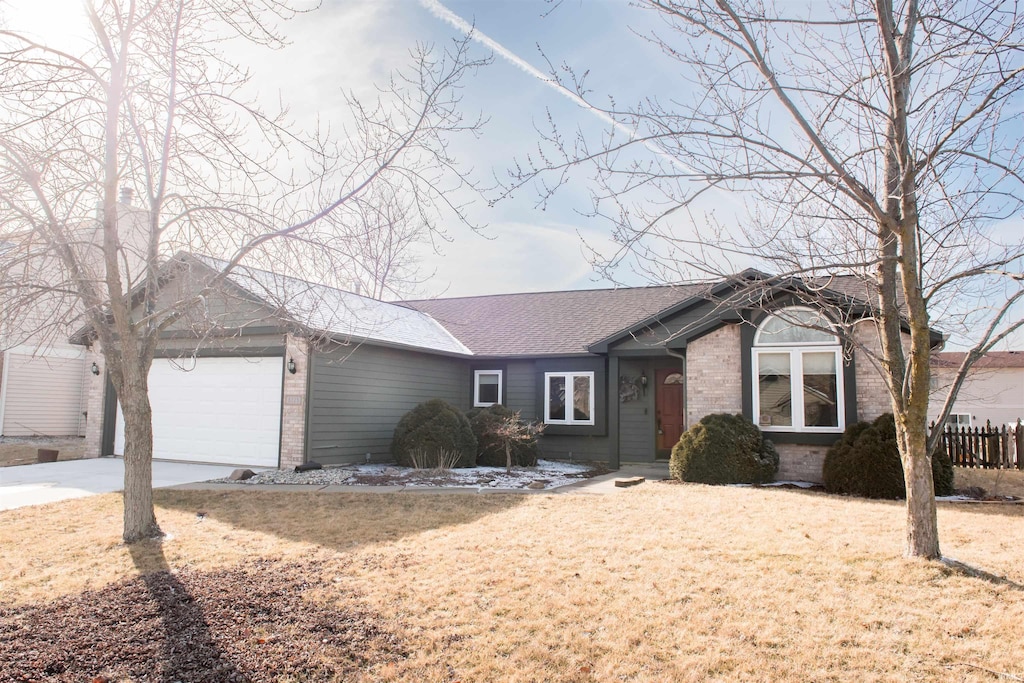 ranch-style house featuring a garage and a front yard