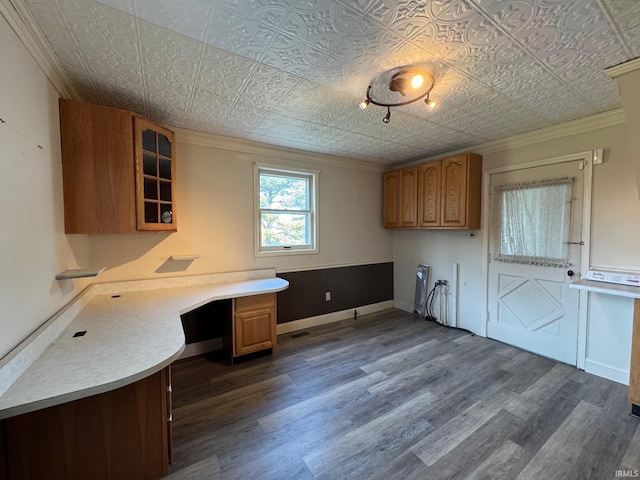 kitchen featuring ornamental molding, dark wood-type flooring, and built in desk