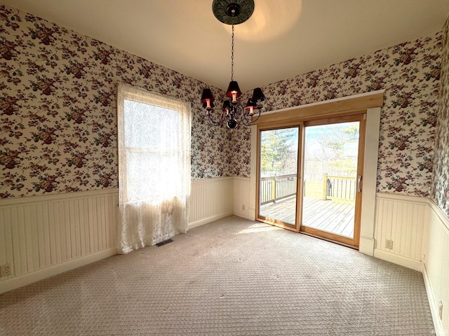 unfurnished dining area featuring carpet floors, radiator, and a chandelier