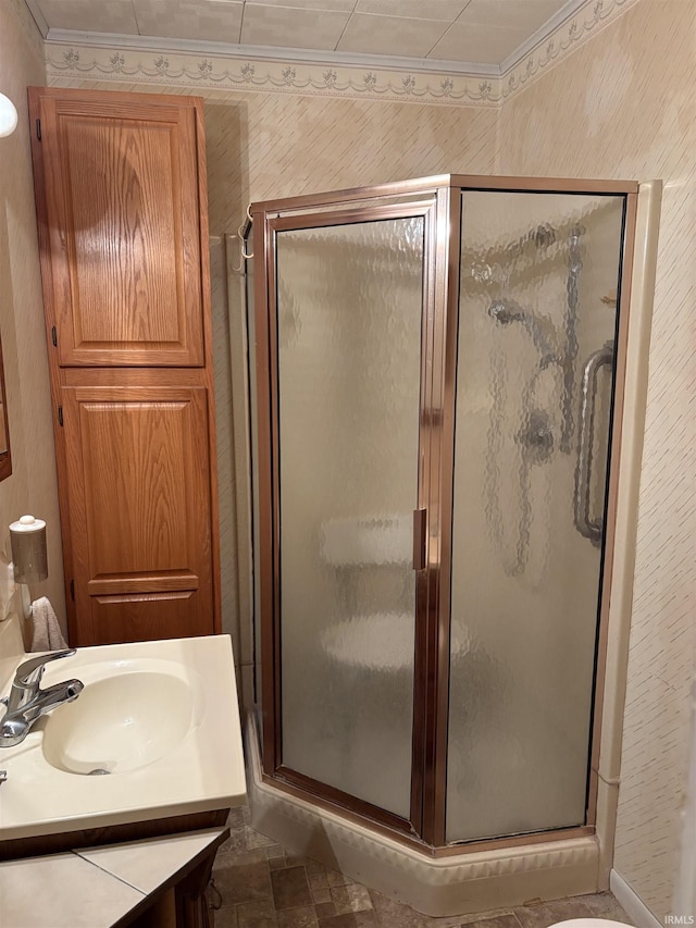 bathroom featuring crown molding, an enclosed shower, and vanity