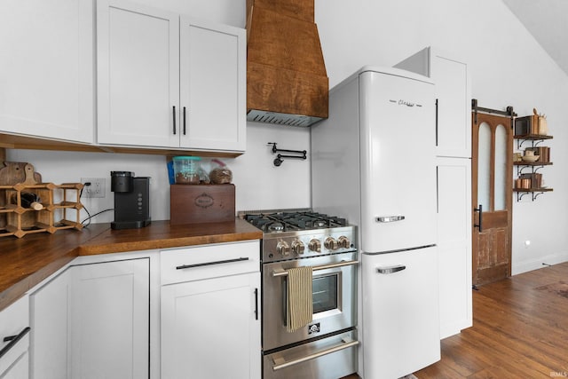 kitchen featuring dark hardwood / wood-style flooring, high end stove, white cabinets, and premium range hood