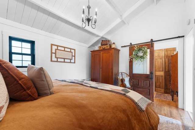 bedroom featuring vaulted ceiling with beams, light hardwood / wood-style floors, wooden ceiling, a barn door, and a chandelier