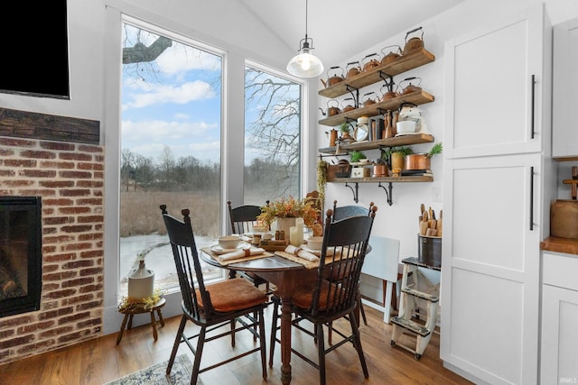 dining space featuring lofted ceiling and light hardwood / wood-style flooring