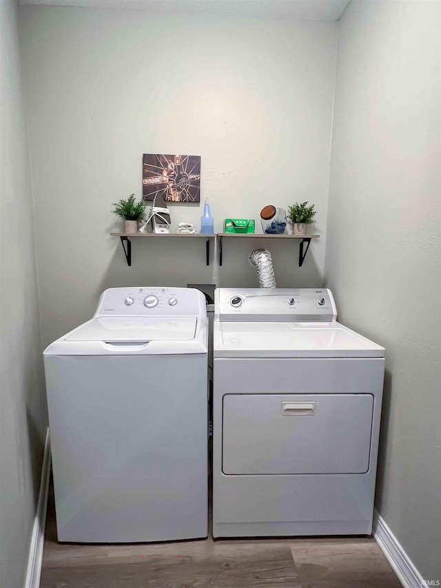 clothes washing area featuring wood-type flooring and independent washer and dryer