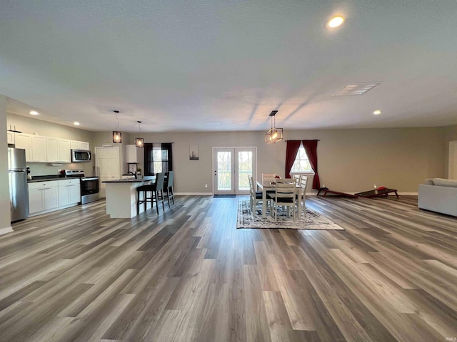 dining space featuring french doors, wood-type flooring, and a textured ceiling