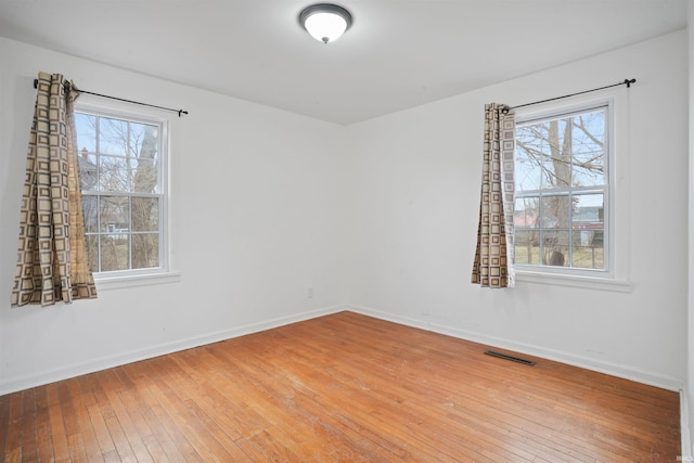 empty room featuring hardwood / wood-style flooring and a healthy amount of sunlight