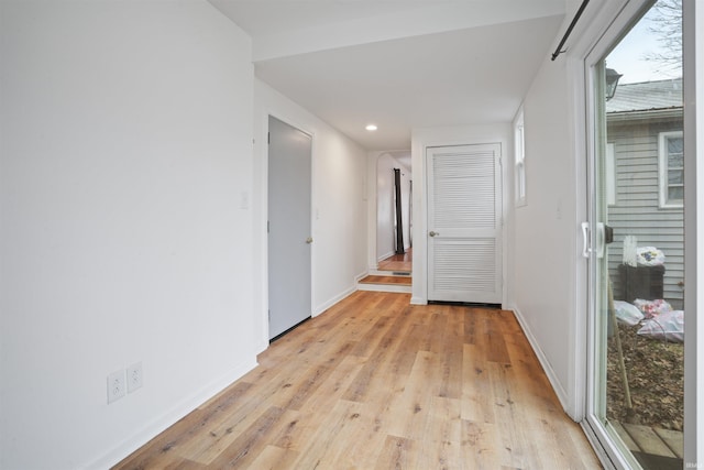 hallway featuring plenty of natural light and light hardwood / wood-style floors