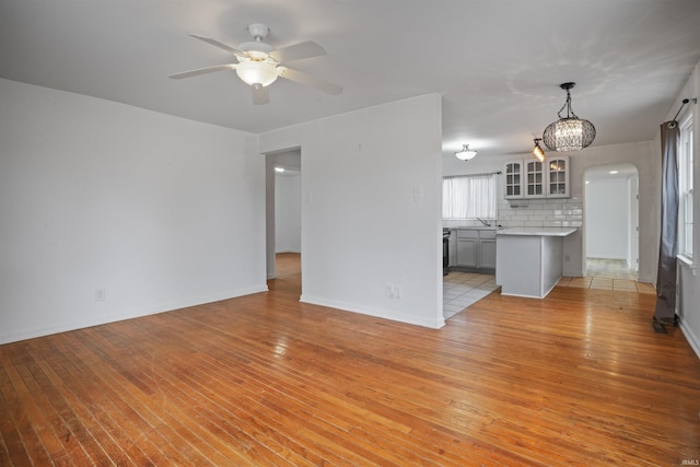 unfurnished living room featuring ceiling fan and light wood-type flooring