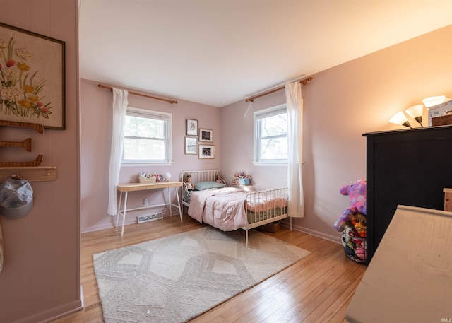 bedroom featuring multiple windows and light hardwood / wood-style floors