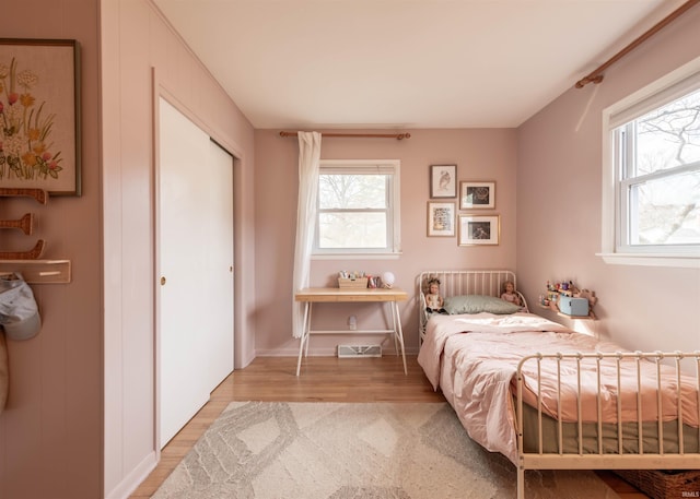 bedroom with light hardwood / wood-style floors and a closet