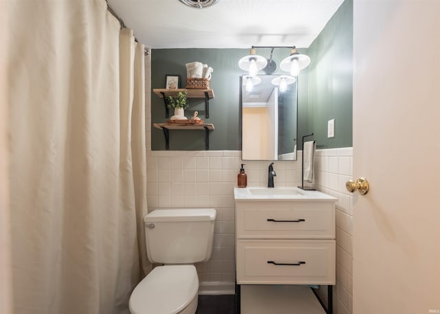 bathroom with a shower with curtain, vanity, tile walls, and toilet