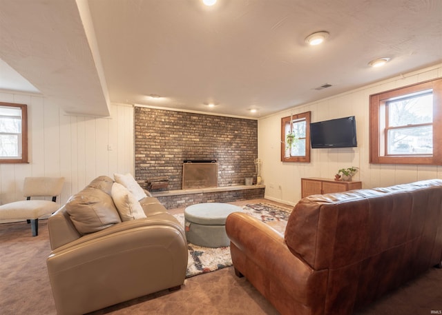 carpeted living room with a brick fireplace and a wealth of natural light