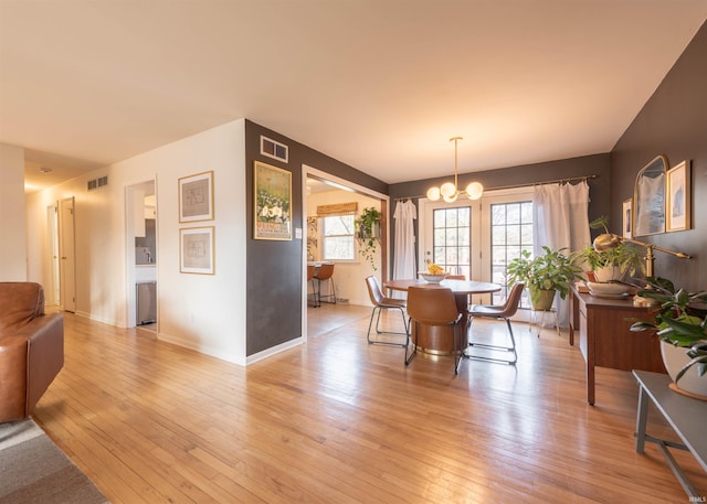 dining area with a notable chandelier and light wood-type flooring