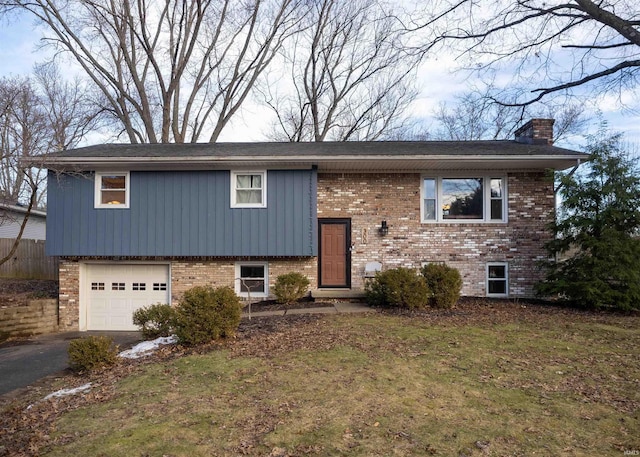 split foyer home featuring a garage and a front lawn