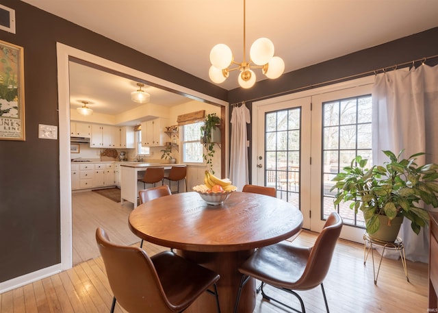 dining area featuring a chandelier, sink, and light hardwood / wood-style flooring