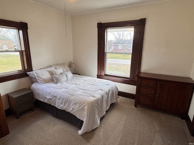 bedroom with multiple windows and light carpet