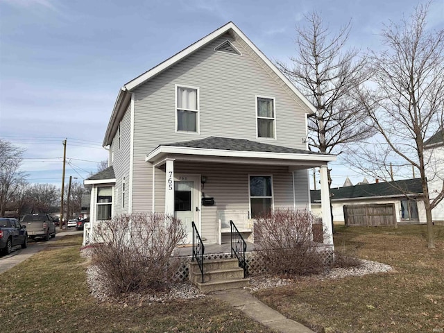 view of property featuring a porch and a front lawn