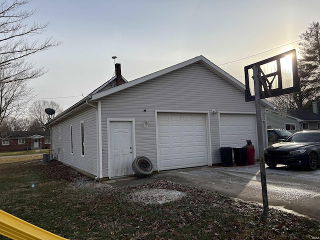 property exterior at dusk with a garage, central AC, and an outdoor structure