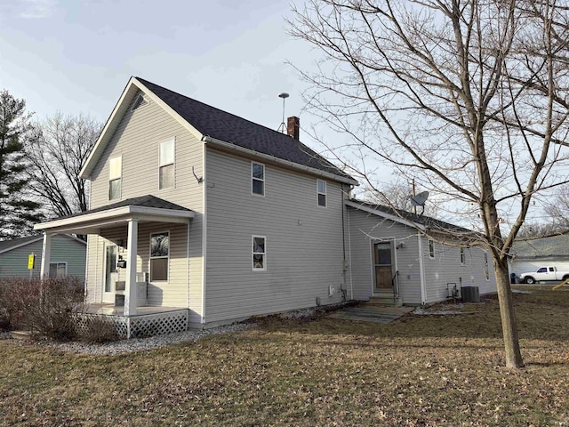 back of property featuring a yard, central air condition unit, and covered porch