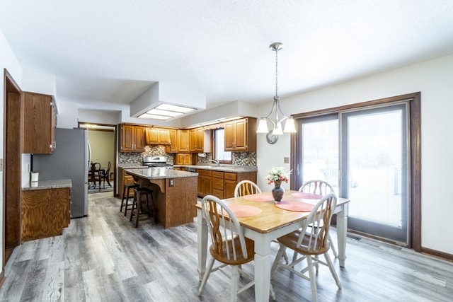 dining space featuring sink and light hardwood / wood-style flooring