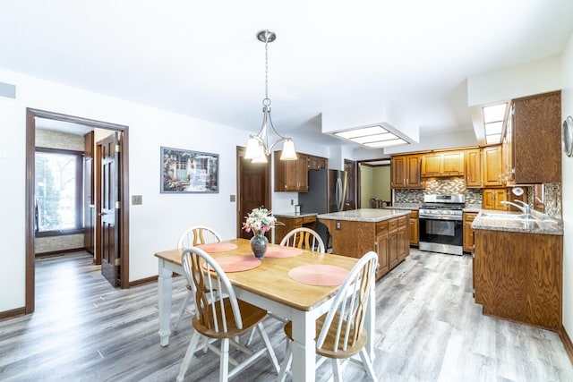 dining space with sink and light hardwood / wood-style flooring