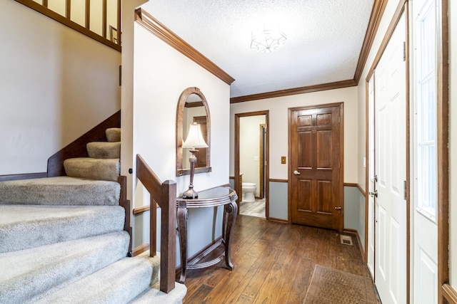 entryway featuring crown molding, dark hardwood / wood-style floors, and a textured ceiling