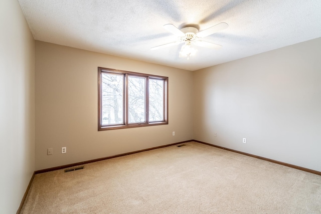 carpeted empty room with a textured ceiling and ceiling fan