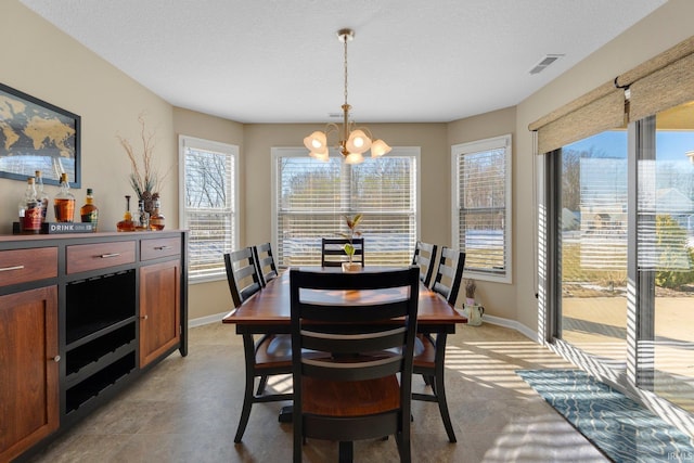 dining space with a textured ceiling and a notable chandelier