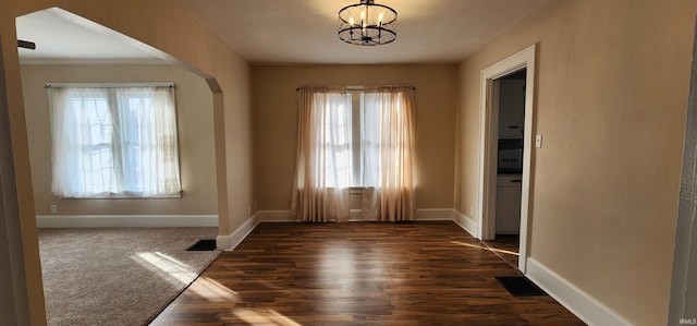 interior space featuring a notable chandelier and dark carpet