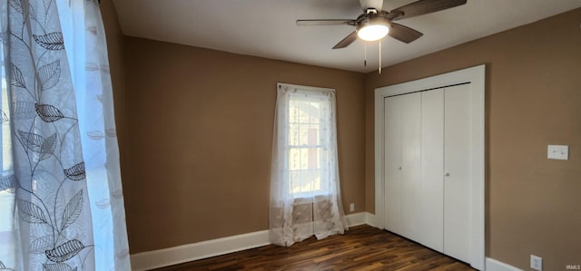 unfurnished bedroom featuring dark hardwood / wood-style floors, ceiling fan, and a closet