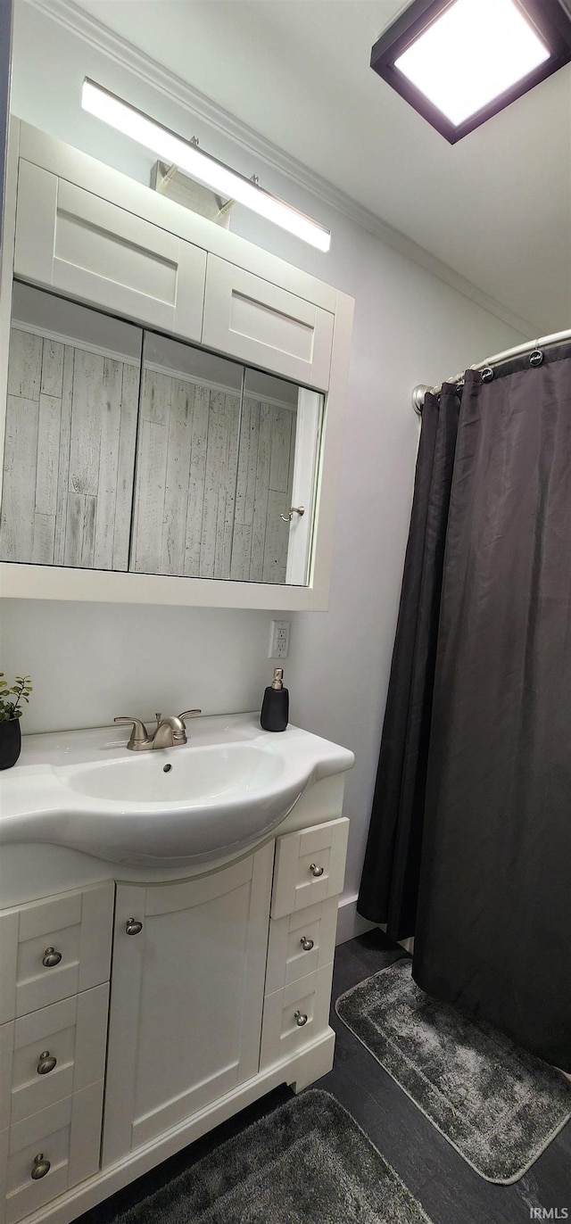 bathroom featuring vanity, curtained shower, and crown molding