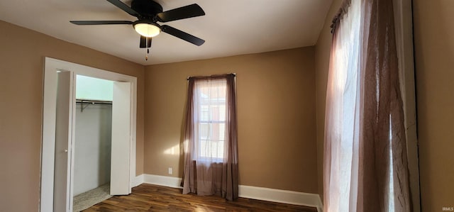 unfurnished bedroom with a closet, dark hardwood / wood-style floors, and ceiling fan