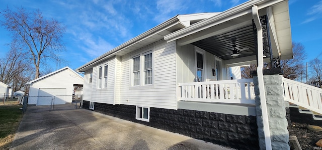 view of home's exterior featuring ceiling fan, a garage, an outdoor structure, and a porch