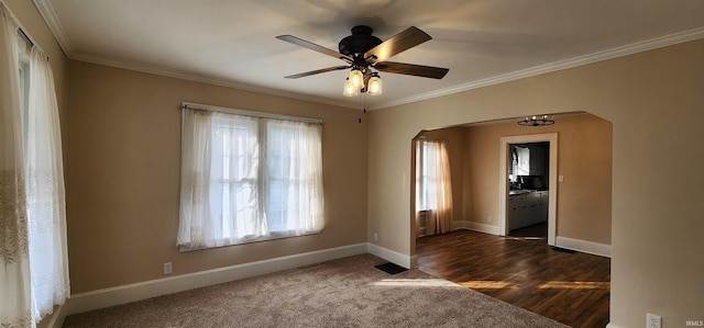 carpeted spare room featuring crown molding and ceiling fan