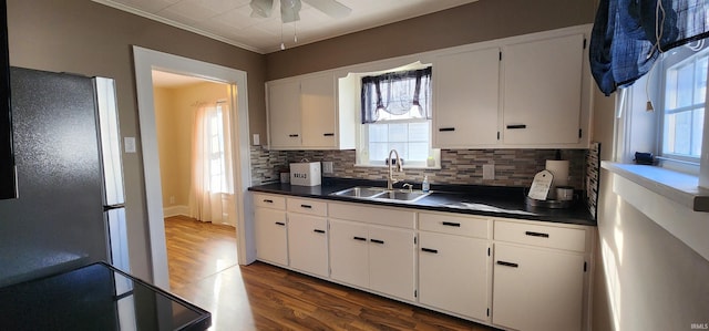 kitchen featuring dark wood-type flooring, sink, tasteful backsplash, stainless steel fridge, and white cabinets