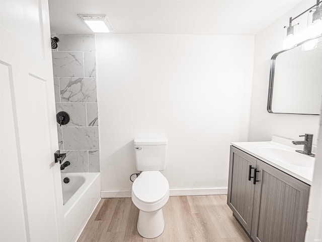 bathroom featuring baseboards, wood finished floors, toilet, vanity, and  shower combination