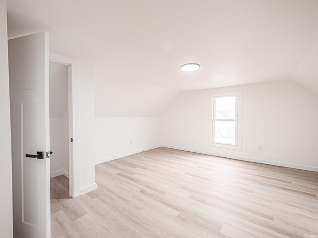 bonus room featuring baseboards, vaulted ceiling, and light wood-type flooring