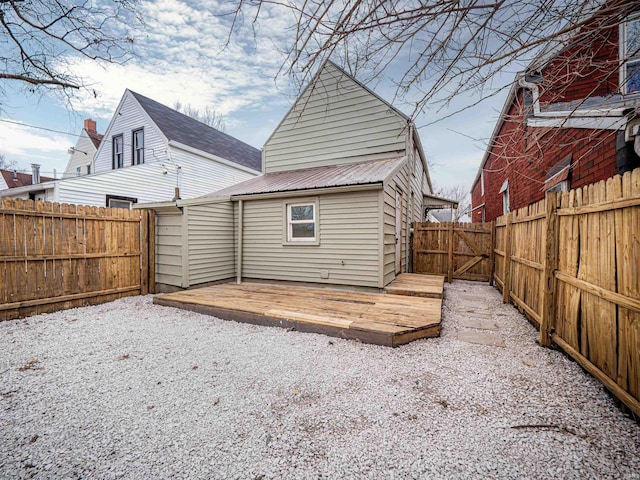 rear view of house with a fenced backyard and a wooden deck