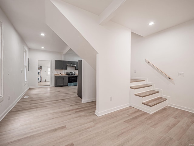 unfurnished living room with baseboards, recessed lighting, and light wood-style floors