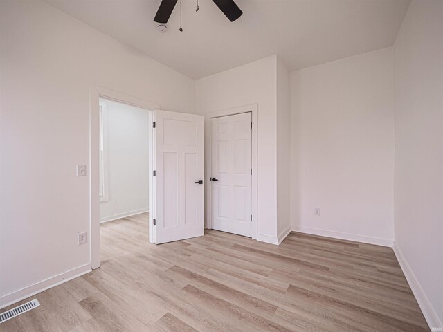 unfurnished bedroom with a ceiling fan, light wood-style flooring, baseboards, and visible vents