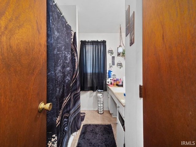 bathroom with tile patterned flooring, vanity, and curtained shower